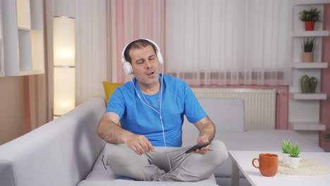 Man-listening-to-music-with-headphones-is-unhappy-and-sad.